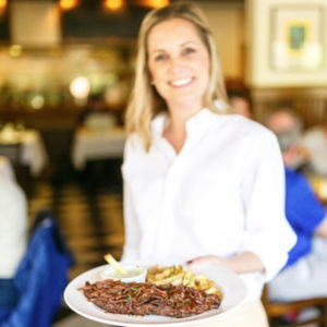 Woman serving food at Mustards Restaurant